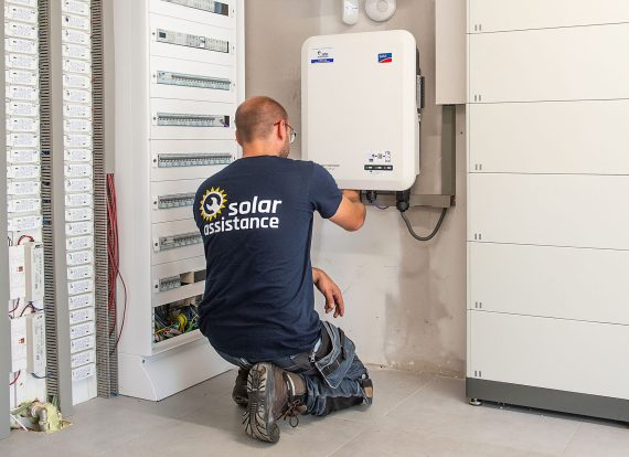 Technieker van Solar Assistance aan het werk aan een omvormer